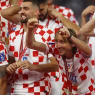 Chrovatský fotbalový reprezentant Luka Modrič slaví v hloučku spoluhráčů bronz na fotbalovém MS v Kataru.