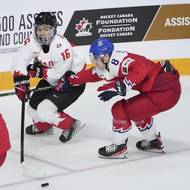 Kanadský hokejista Connor Bedard (16) v akci během finále MS dvacítek spolu s českým reprezentantem Davidem Moravcem.