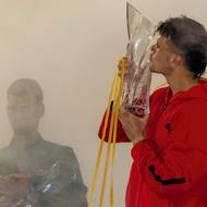 Vítěz Jakub Menšík s trofejí z novoborské sklárny Lasvit. V pozadí stojí poražený Novak Djokovič.