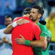 Jakub Menšík se objímá na konci utkání s poraženým Novakem Djokovičem. Právě díky němu začal Menšík s tenisem.