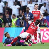 Útočník Arsenalo Bukayo Saka svádí souboj o míč s Desirem Douém z PSG.