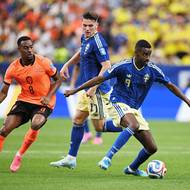 Švéd Alexander Isak s míčem u nohy, napadá ho Nizozemec Ryan Gravenberch.
