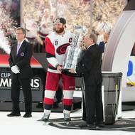 Kapitán hokejistů Caroliny Jordan Staal přebírá pohár s rukou komisaře NHL Garyho Bettmana.