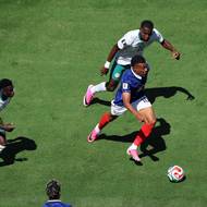 Francouzský útočník Kylian Mbappé mezi dvěma Senegalci.
