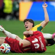 Hakan Çalhanoğlu (vlevo) zastavuje skluzem Australana Jordana Bose v zápase MS ve fotbale.