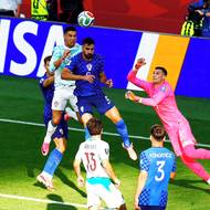Cristiano Ronaldo v hlavičkovém souboji s Josipem Sutalem a zasáhnout se chystá Dominik Livakovič. 